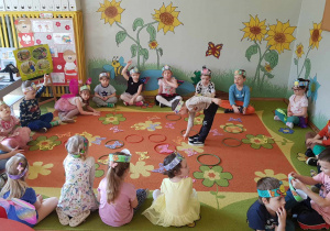 Dzień motyla - dzieci siedzą na dywanie i segregują motyle wkładając je do kółek