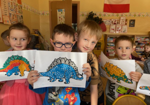 dzieci pokazujące kolorowe dinozaury