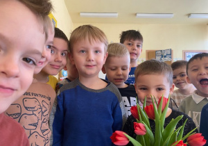 grupa chłopców z czerwonymi tulipanami