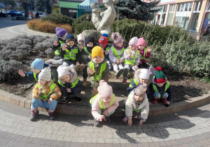 Dzieci pozują do zdjęcia na placu przed biblioteką