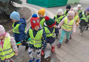 Dzieci ustawione parami przy wężu spacerują z powrotem do przedszkola