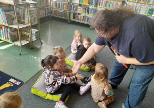 Dzieci pasowane są na czytelników przez pana bibliotekarza