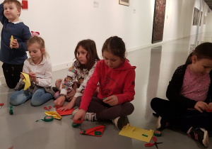 W Muzeum Sztuki - warsztaty; dzieci tworzą rzeźby z papieru.
