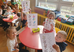 Dzieci przy stoliku kolorujące obrazki ze skarpetkami