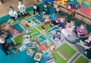 Na dywanie rozłożone są książeczki przyniesione przez dzieci