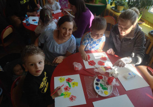 Rodzice wspólnie z dziećmi malują wiosenne kwiaty