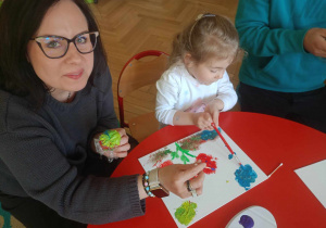 Dziewczynka maluje z mamą obraz