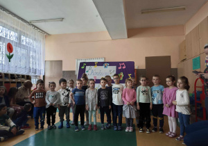 Dzieci stojące w jednej grupie na tle napisu konkurs